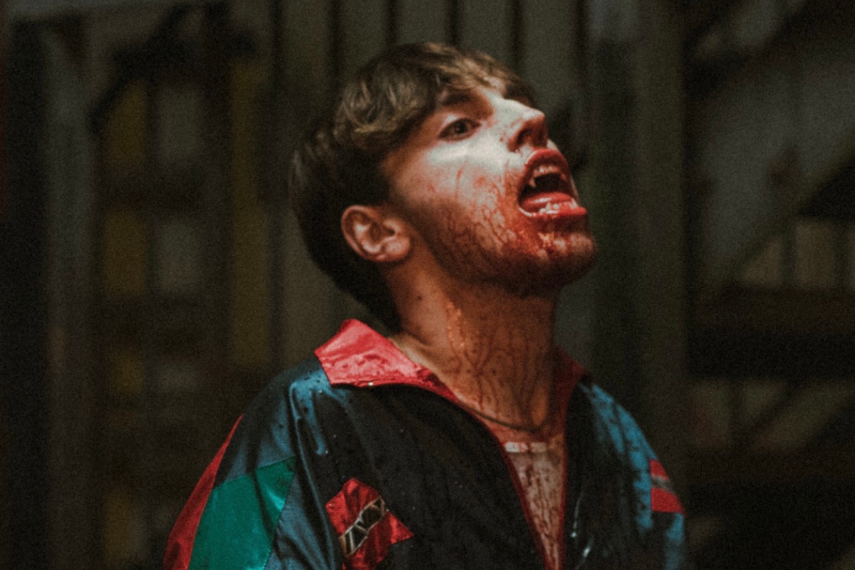 Max Harwood as titular character vampire Seagull, covered in blood and showing his fangs.